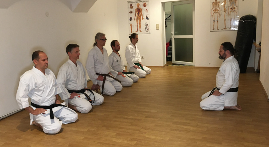 1. Training im Dojo: 6 Karateka sitzen im Fersensitz